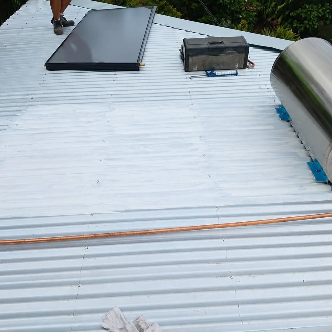 Toiture en tôle ondulée gris clair fraîchement traitée, avec un panneau solaire
